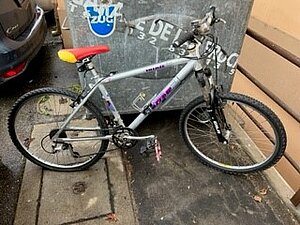 vélo gris avec autocollant violet